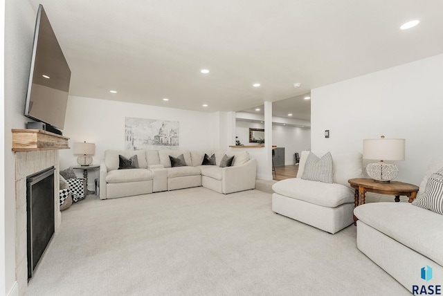 living area with a fireplace, recessed lighting, and light colored carpet