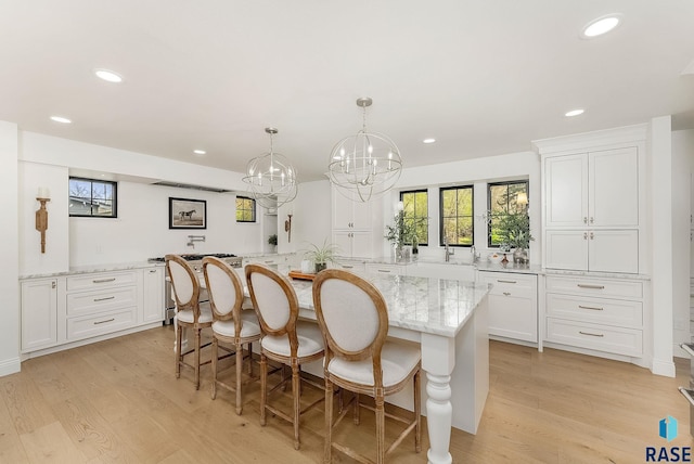 kitchen featuring an inviting chandelier, recessed lighting, white cabinets, and light wood finished floors