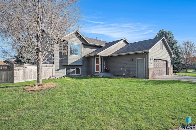 split level home with a garage, brick siding, fence, aphalt driveway, and a front lawn