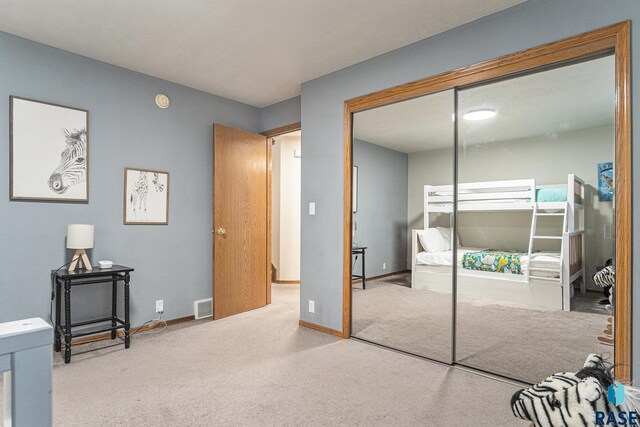 unfurnished bedroom featuring carpet floors, baseboards, visible vents, and a closet