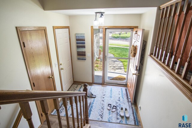 foyer entrance featuring baseboards and wood finished floors