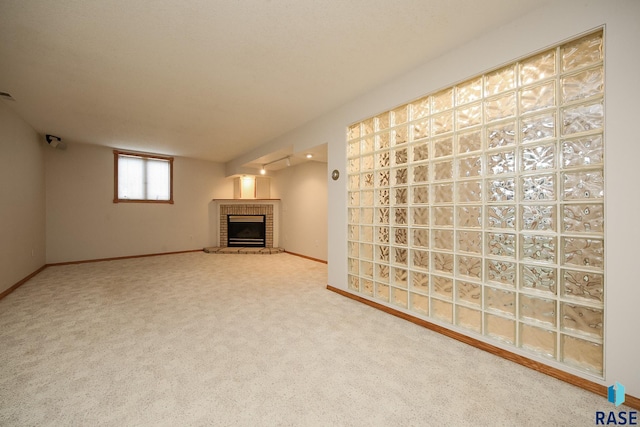 unfurnished living room featuring carpet floors, baseboards, and a brick fireplace