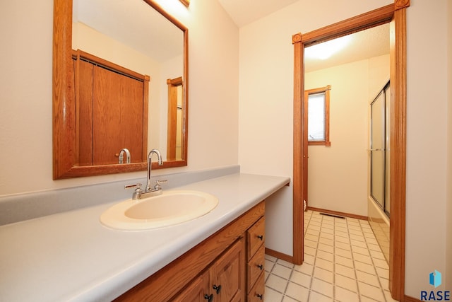 bathroom with vanity, a shower with door, and tile patterned flooring