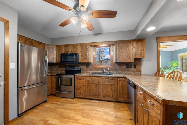4108 E 23rd St, Sioux Falls, SD 57103 - kitchen with a sink, a ceiling fan, stainless steel appliances, and light wood-style flooring