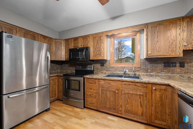 4108 E 23rd St, Sioux Falls, SD 57103 - kitchen with brown cabinets, ceiling fan, appliances with stainless steel finishes, and a sink