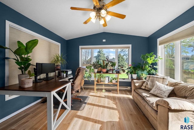 4108 E 23rd St, Sioux Falls, SD 57103 - home office with a healthy amount of sunlight, vaulted ceiling, a baseboard heating unit, and wood finished floors