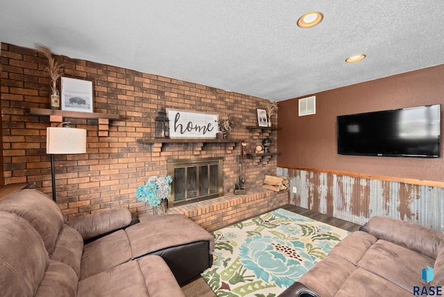 4108 E 23rd St, Sioux Falls, SD 57103 - living area with a brick fireplace, a textured ceiling, a wainscoted wall, wood finished floors, and visible vents