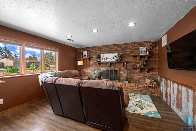 4108 E 23rd St, Sioux Falls, SD 57103 - living room with a brick fireplace, a textured ceiling, recessed lighting, wood finished floors, and visible vents