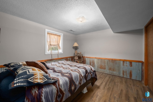 4108 E 23rd St, Sioux Falls, SD 57103 - bedroom with visible vents, a textured ceiling, wood finished floors, and a wainscoted wall