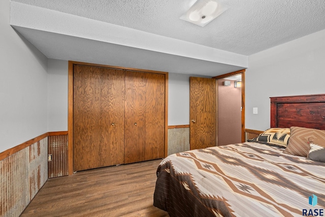 4108 E 23rd St, Sioux Falls, SD 57103 - bedroom with a textured ceiling, a wainscoted wall, a closet, and wood finished floors