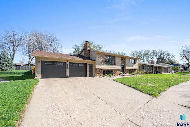 4108 E 23rd St, Sioux Falls, SD 57103 - tri-level home with fence, an attached garage, a chimney, and a front yard