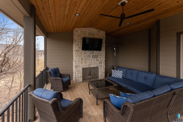 view of patio featuring ceiling fan and an outdoor living space with a fireplace