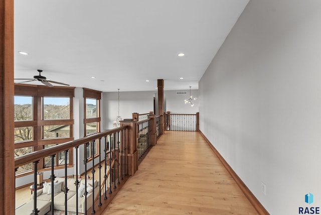 corridor featuring a chandelier, visible vents, an upstairs landing, light wood-style floors, and recessed lighting