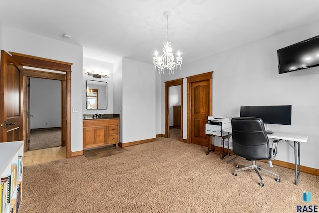 office space featuring an inviting chandelier, baseboards, carpet, and a sink