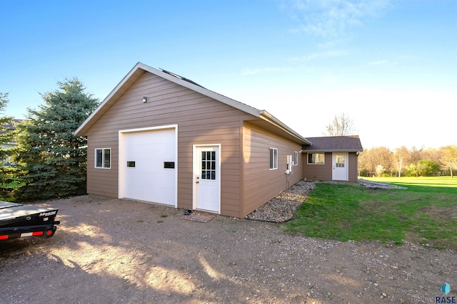 exterior space featuring a lawn, an outdoor structure, and a garage