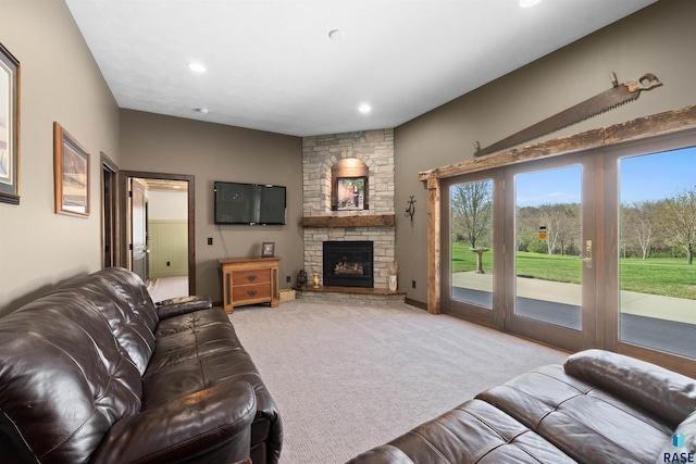 carpeted living area featuring recessed lighting and a stone fireplace