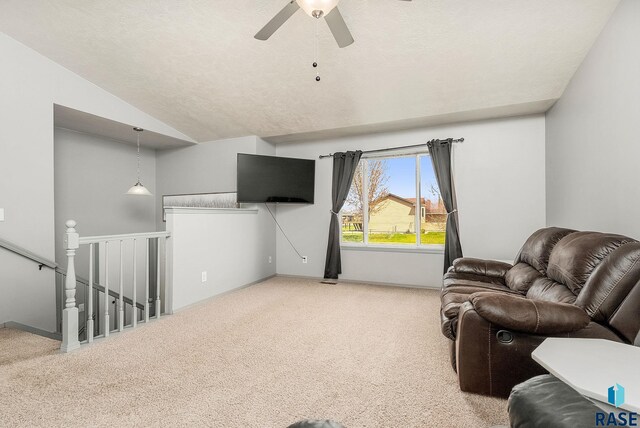 living area featuring baseboards, carpet flooring, a ceiling fan, and lofted ceiling