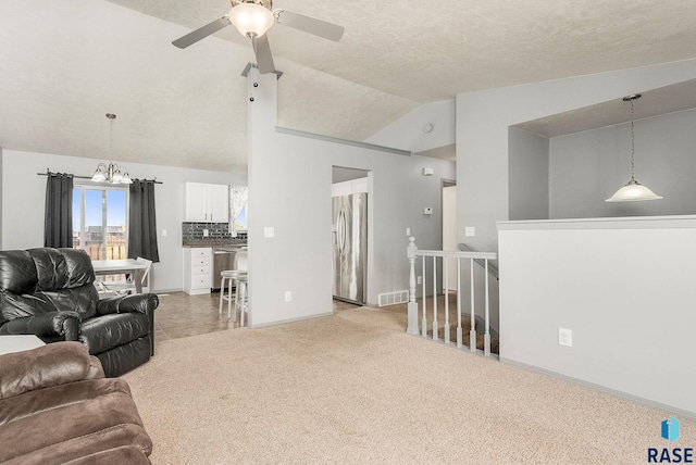 living area with light colored carpet, visible vents, vaulted ceiling, baseboards, and ceiling fan with notable chandelier