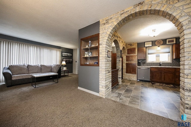interior space featuring a healthy amount of sunlight, arched walkways, a textured ceiling, and dishwasher