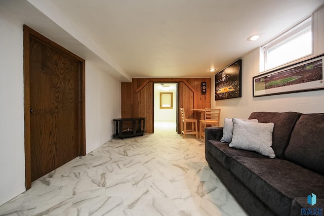 living room with wooden walls, recessed lighting, and marble finish floor