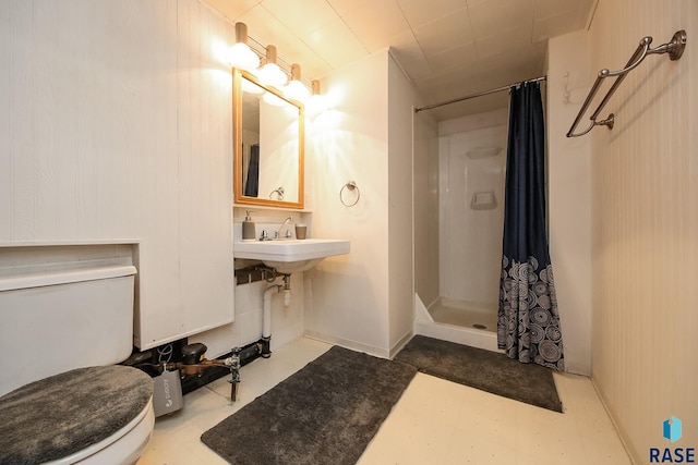 full bath featuring toilet, tile patterned floors, and a shower stall