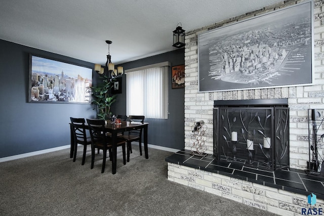 carpeted dining area featuring a brick fireplace, a textured ceiling, baseboards, and a chandelier