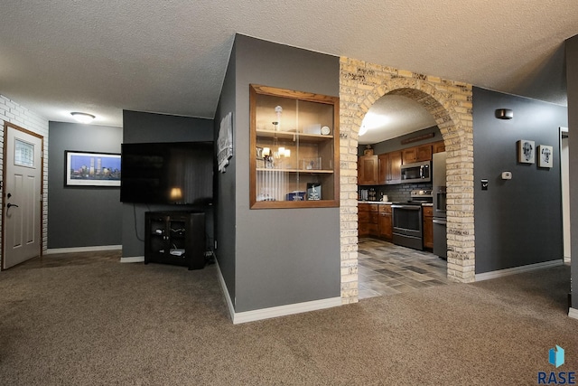 kitchen featuring carpet floors, baseboards, a textured ceiling, electric range oven, and stainless steel microwave