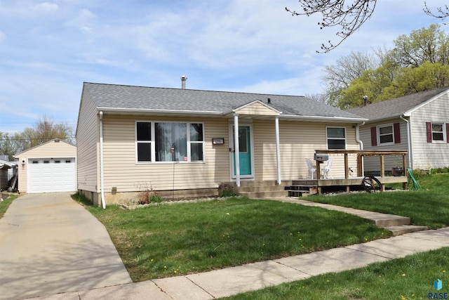 view of front of home featuring a detached garage, driveway, an outbuilding, and a front lawn