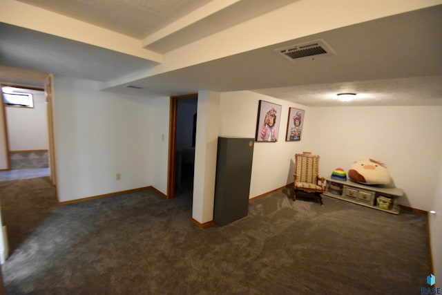 finished basement featuring baseboards, dark carpet, and visible vents