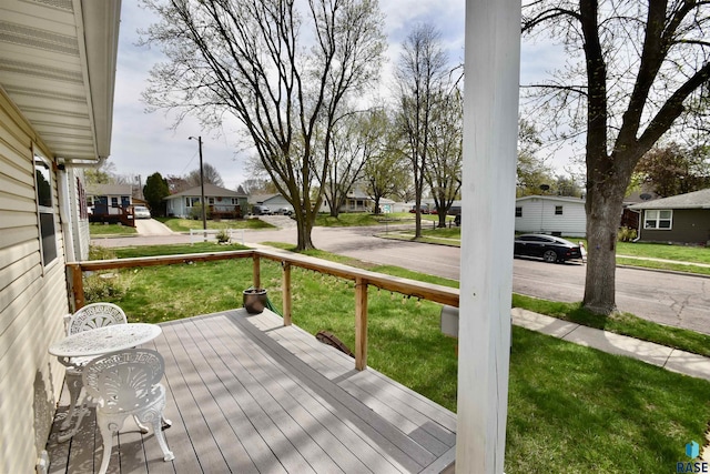 wooden deck with a yard, a residential view, and covered porch