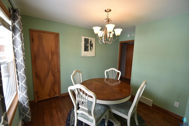 dining space with baseboards, a notable chandelier, wood finished floors, and visible vents