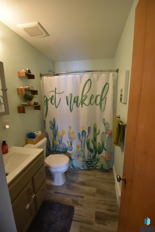 full bathroom featuring a shower with curtain, visible vents, wood finished floors, vanity, and toilet