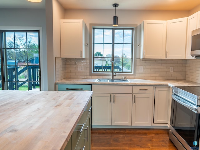 kitchen with decorative backsplash, a sink, stainless steel appliances, white cabinetry, and dark wood-type flooring