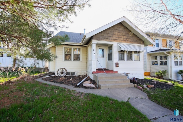 bungalow with fence and a shingled roof