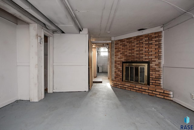 basement featuring baseboards and a fireplace