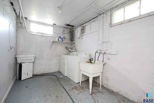 clothes washing area with separate washer and dryer, laundry area, and a wealth of natural light