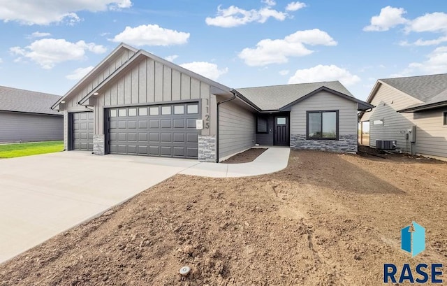 1125 E Wayne Pl, Tea, SD 57064 - ranch-style house with board and batten siding, a garage, stone siding, driveway, and central AC unit