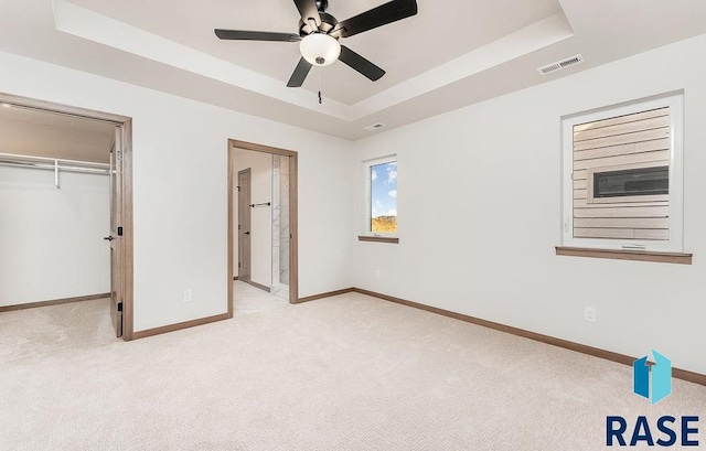 1125 E Wayne Pl, Tea, SD 57064 - unfurnished bedroom with a raised ceiling, light colored carpet, baseboards, and a walk in closet