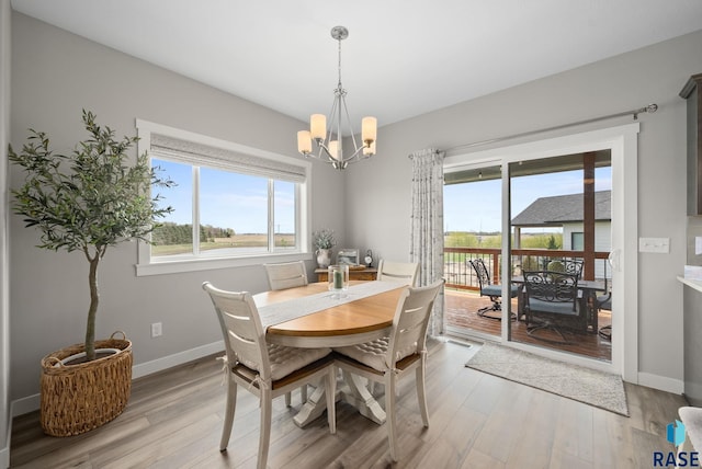 922 Johnson Creek Ct, Harrisburg, SD 57032 - dining area with a chandelier, light wood-style floors, and baseboards