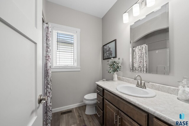 922 Johnson Creek Ct, Harrisburg, SD 57032 - bathroom with toilet, wood finished floors, vanity, baseboards, and a shower with shower curtain