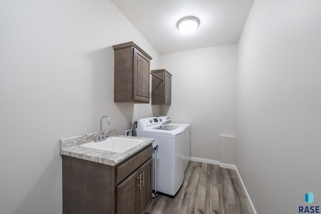 922 Johnson Creek Ct, Harrisburg, SD 57032 - washroom with washing machine and clothes dryer, cabinet space, light wood finished floors, and baseboards
