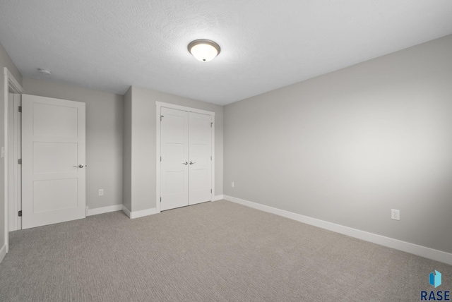 922 Johnson Creek Ct, Harrisburg, SD 57032 - unfurnished bedroom featuring carpet, baseboards, a closet, and a textured ceiling