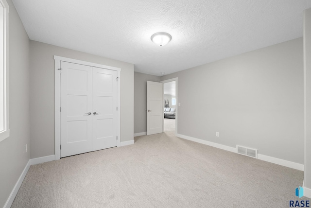 922 Johnson Creek Ct, Harrisburg, SD 57032 - unfurnished bedroom with carpet, baseboards, a closet, and a textured ceiling