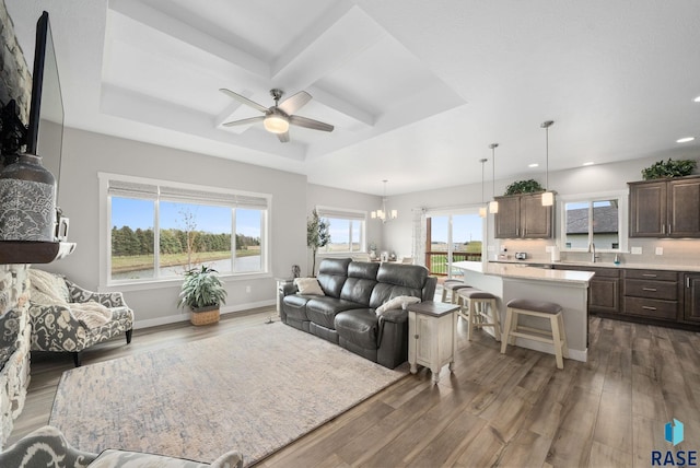 922 Johnson Creek Ct, Harrisburg, SD 57032 - living room with dark wood-style floors, ceiling fan, recessed lighting, coffered ceiling, and a tray ceiling