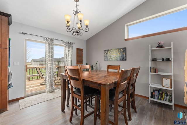 dining room with plenty of natural light, wood finished floors, and lofted ceiling