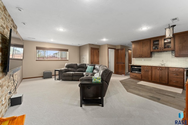 living area with visible vents, recessed lighting, baseboards, and light carpet