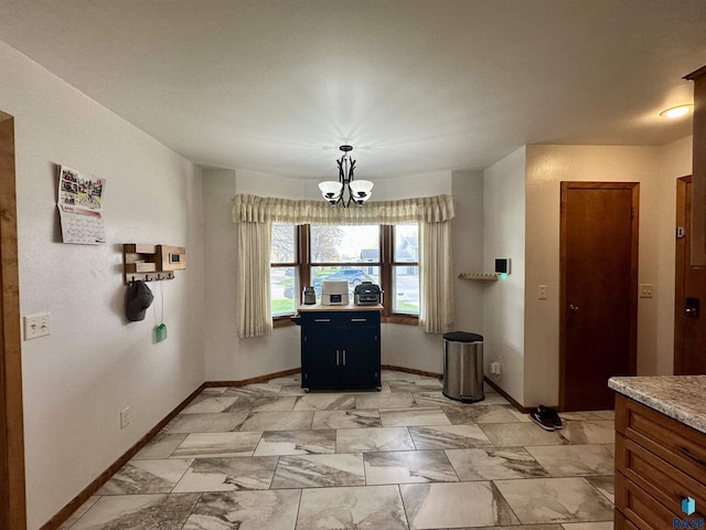 dining space featuring baseboards, an inviting chandelier, and marble finish floor