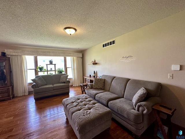 living room featuring visible vents, a textured ceiling, and wood-type flooring