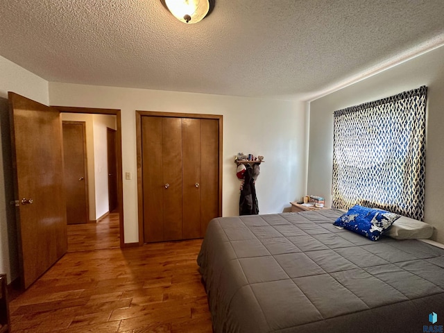 bedroom with a textured ceiling, a closet, and wood finished floors