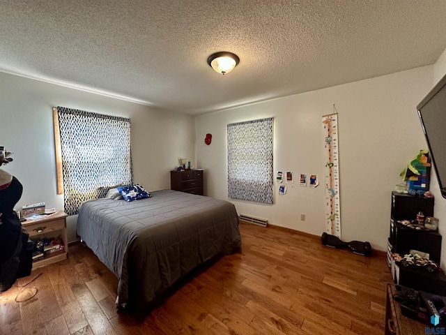 bedroom featuring wood-type flooring, a textured ceiling, and visible vents